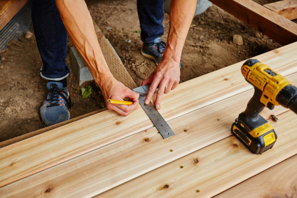 Builder measuring the home to see what deck size works best