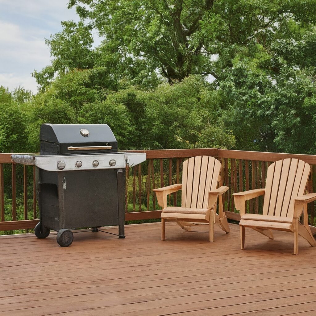 two chairs and grill on wooden deck