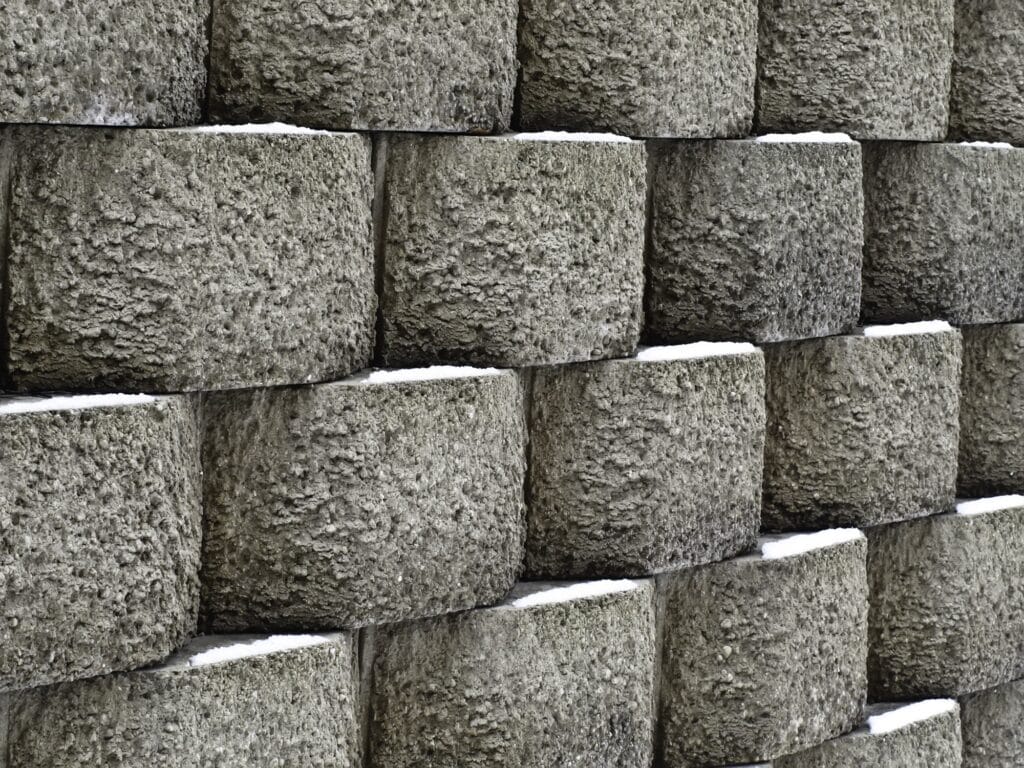 Textured concrete block retaining wall built into a sloped yard